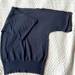 Fashionable grey jersey shirt with boatneck and buttons along dolman sleeves.